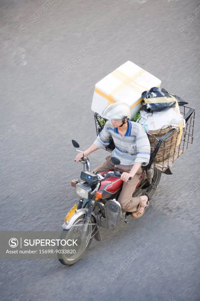 Man riding moped loaded with boxes, high angle view