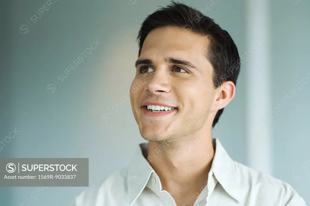 Young man smiling, looking away, portrait