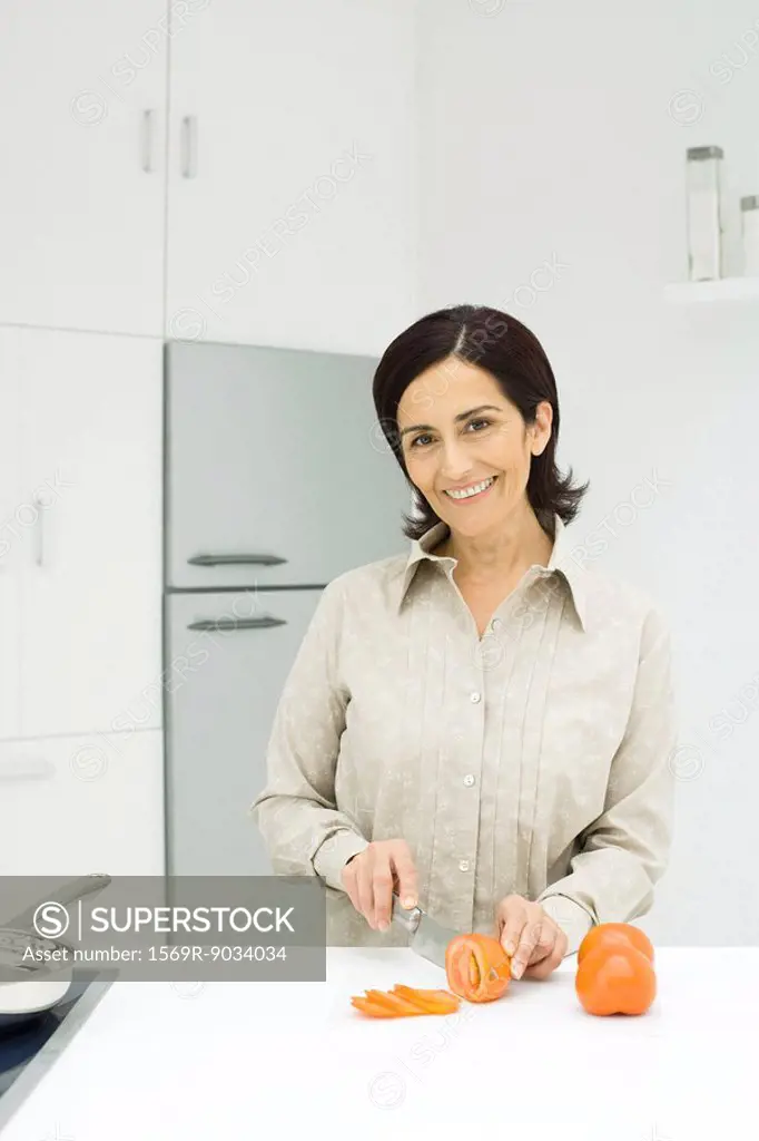 Woman slicing tomatoes in kitchen