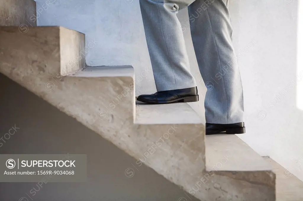 Man walking up staircase, side view, cropped