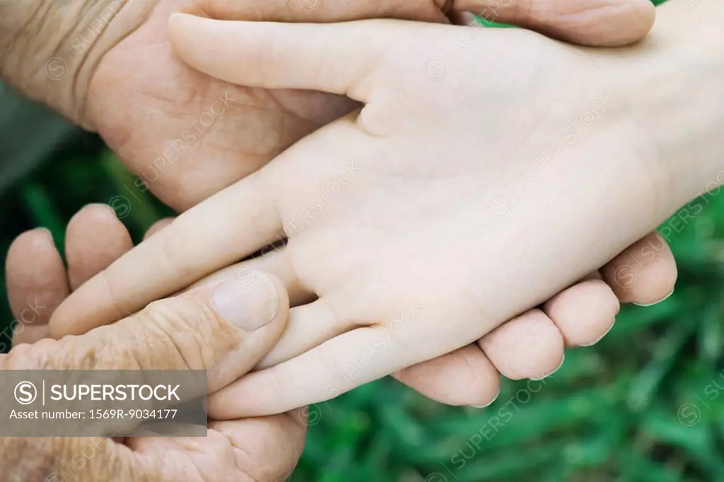 Elderly man holding female´s hand, close-up, cropped view