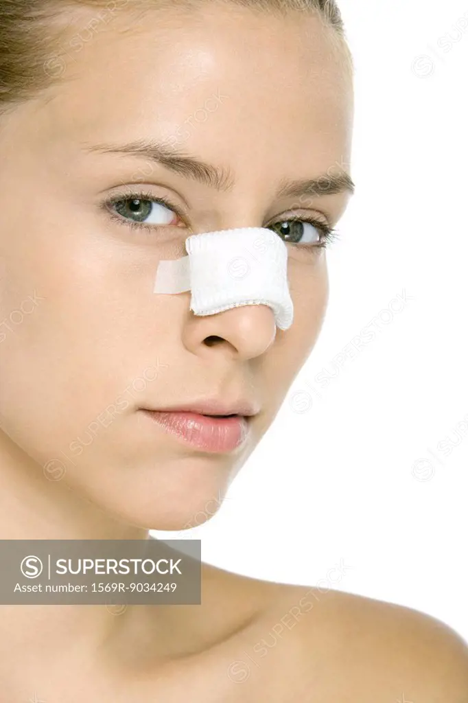 Woman with bandaged nose, looking at camera, close-up