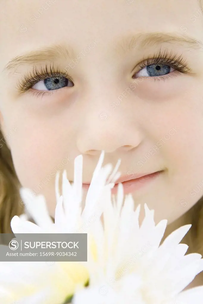 Little girl with flowers, looking up, smiling, portrait