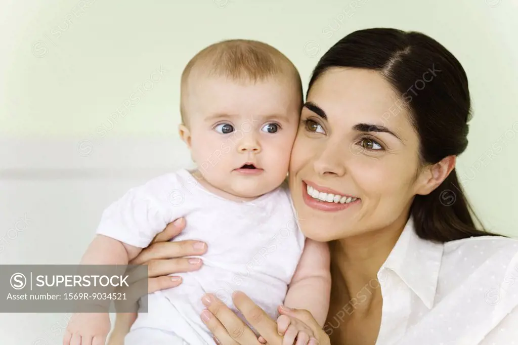 Mother holding infant, smiling, portrait