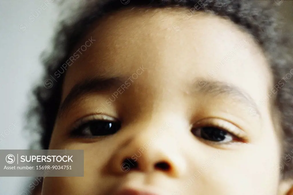Child looking at camera, close-up of face, cropped