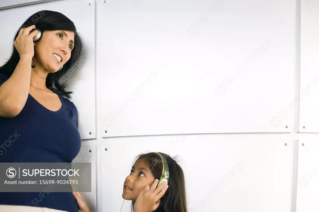 Woman and little girl listening to headphones