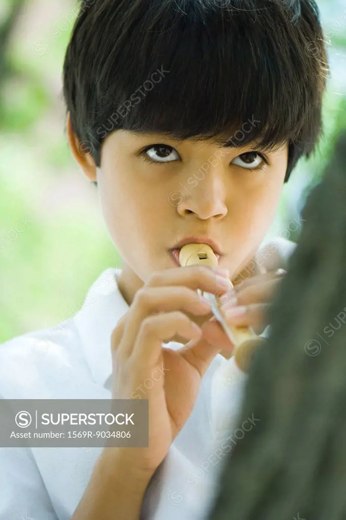 Boy playing recorder, close-up