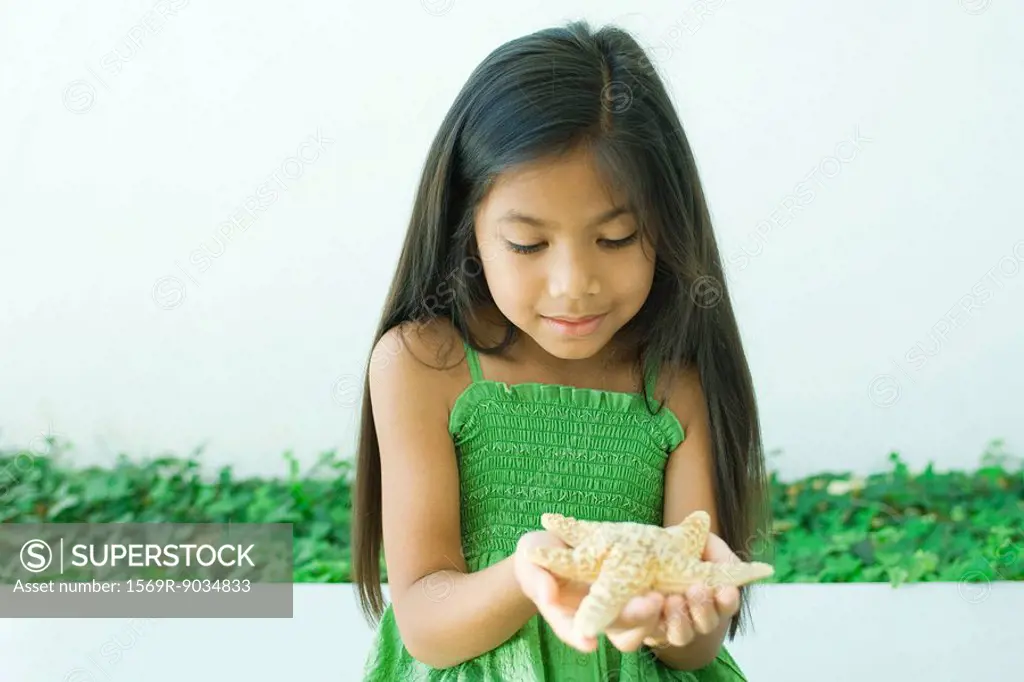 Girl holding starfish in hands