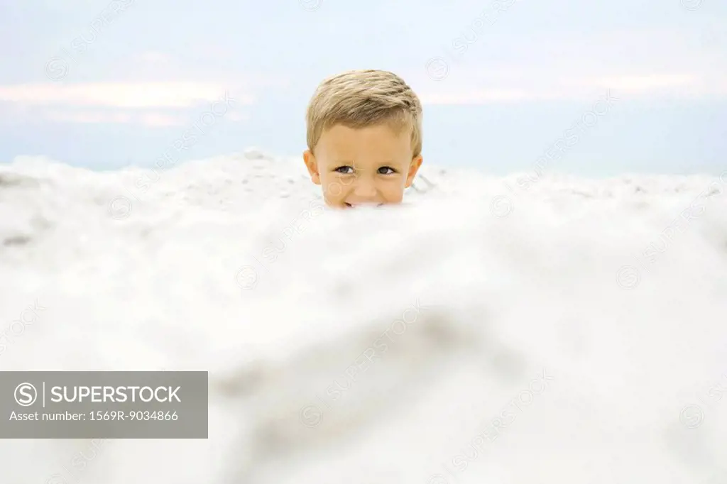 Boy´s head emerging from sand