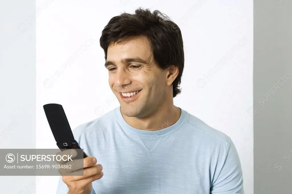 Man looking at cell phone, smiling