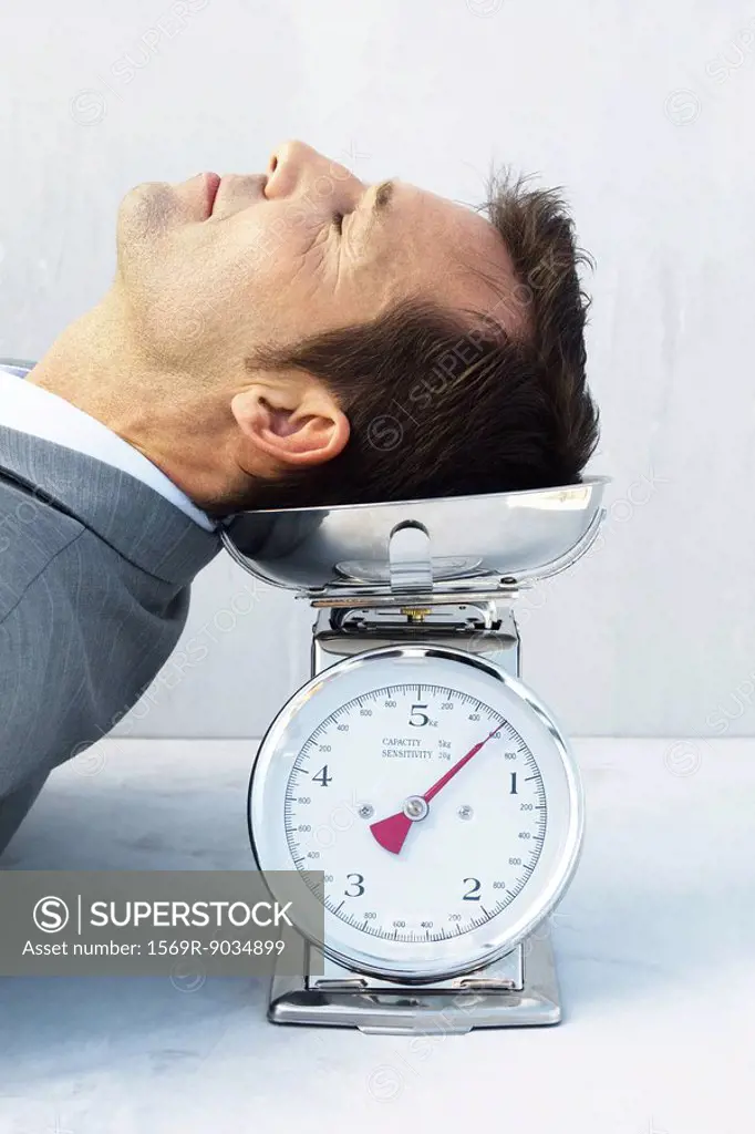 Man resting head on scale, eyes closed