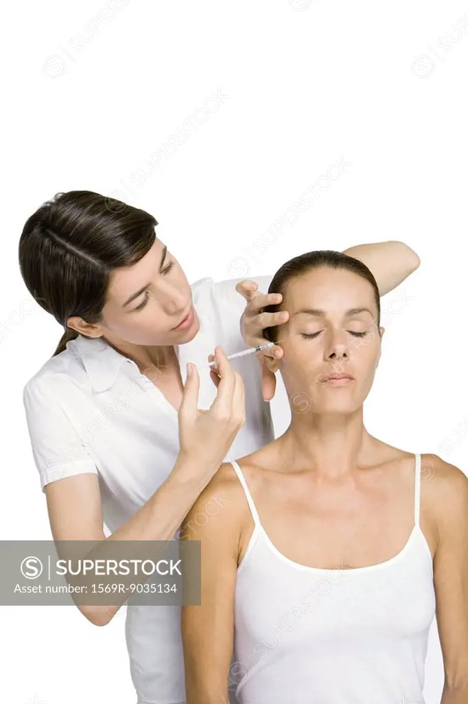 Woman receiving botox injection, eyes closed