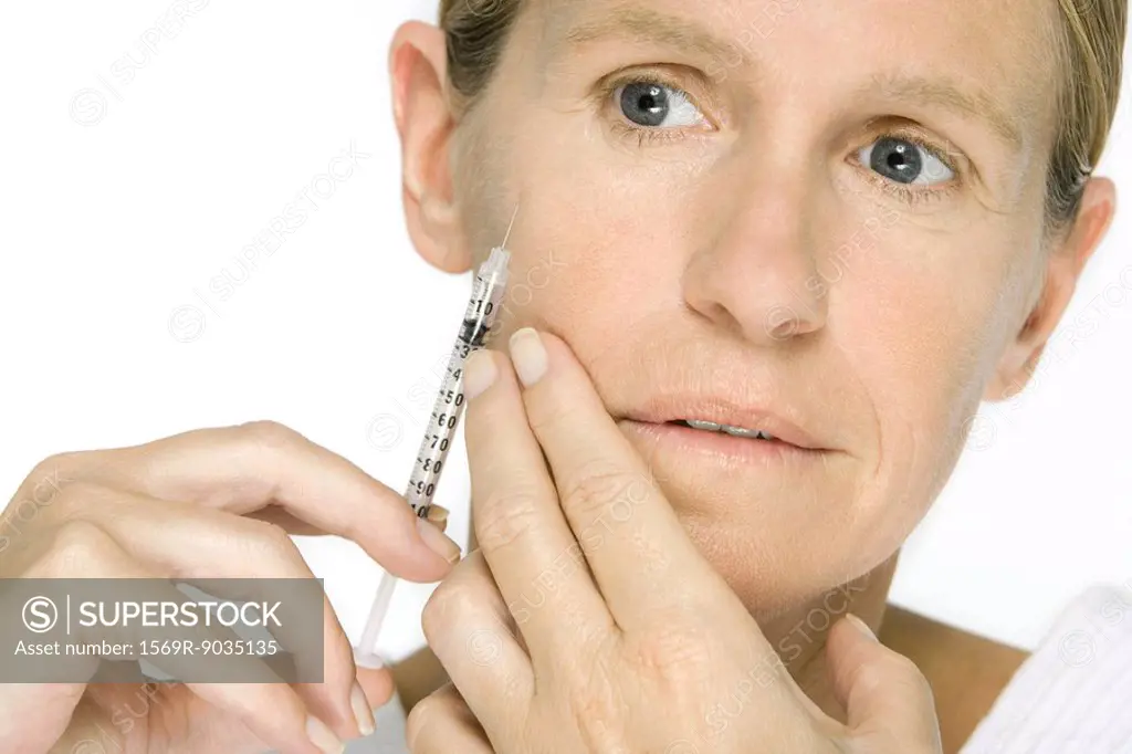 Woman giving herself botox injection, close-up