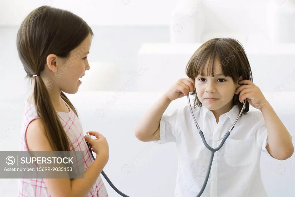 Little boy listening to girl´s heart with stethoscope
