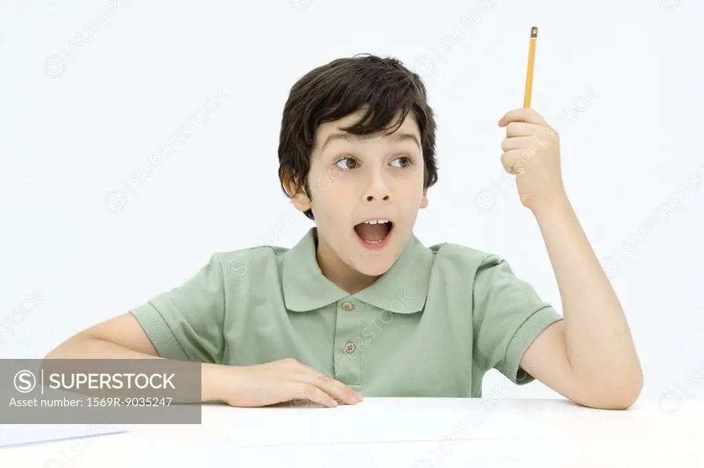 Excited boy holding up pencil, mouth wide open