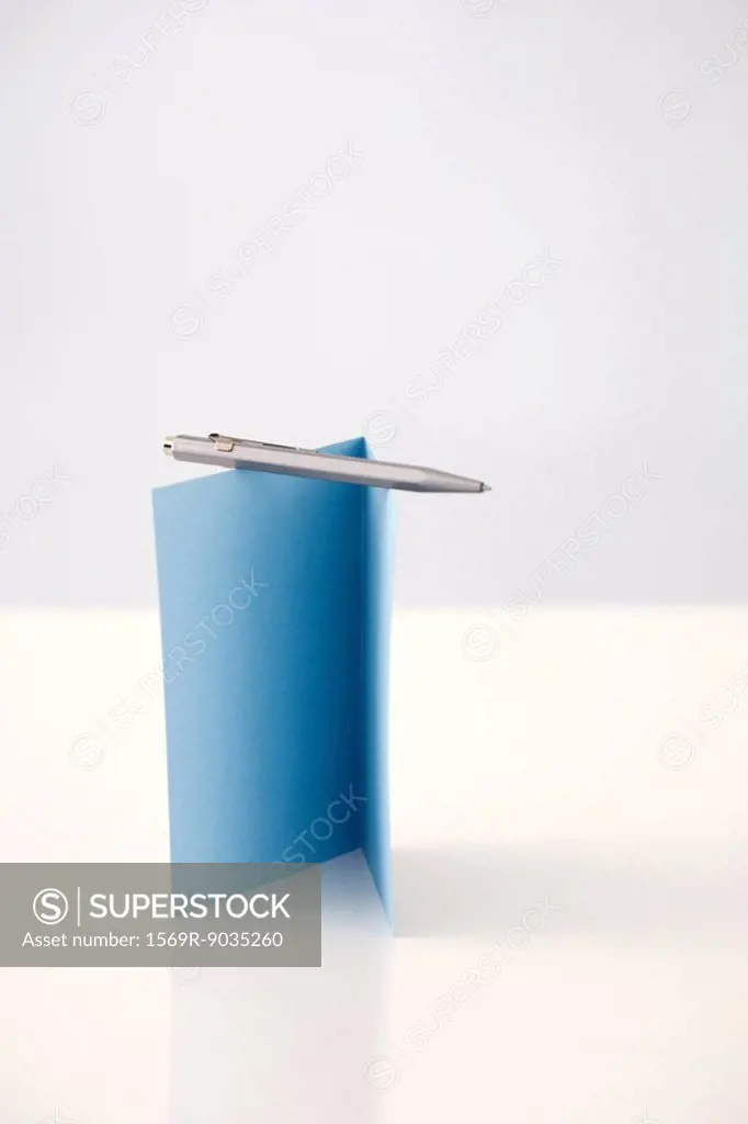 Pen balanced on folded card