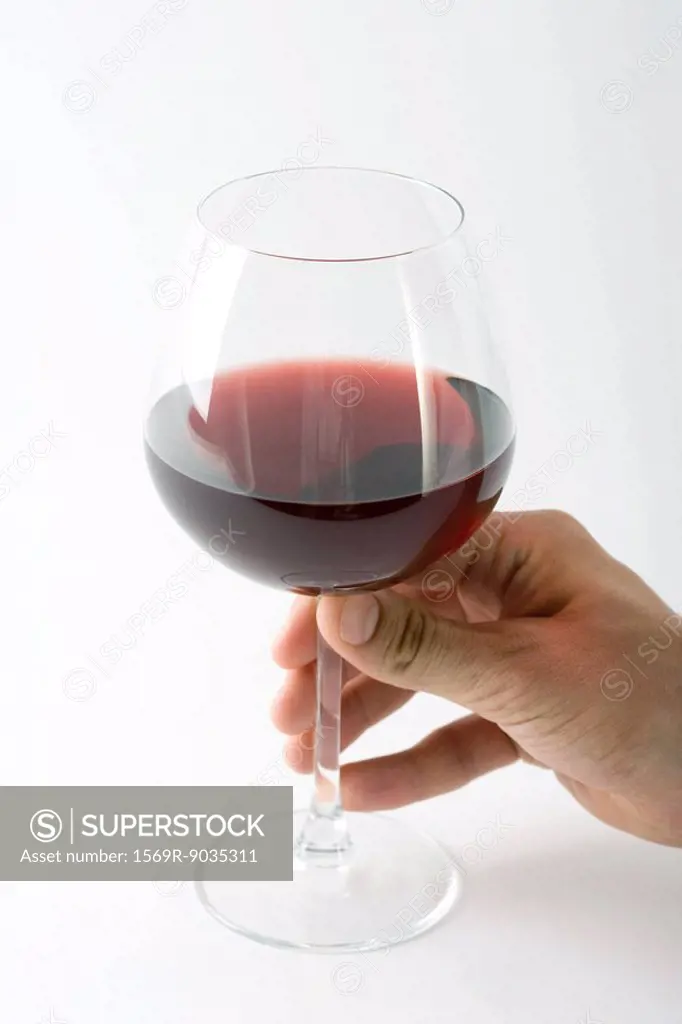 Hand holding glass of red wine, close-up