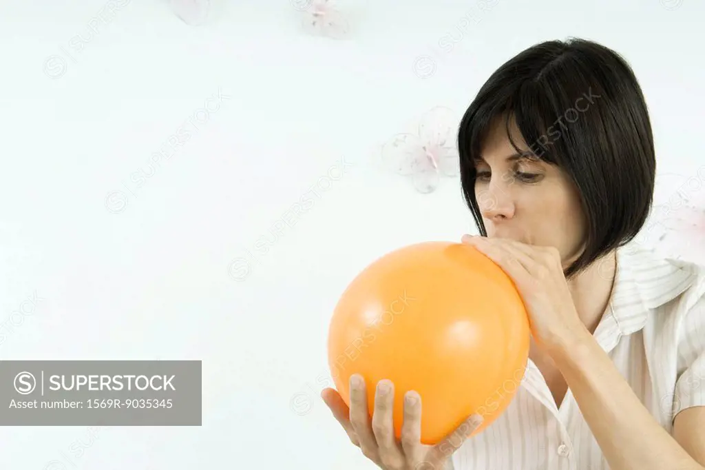 Woman inflating balloon