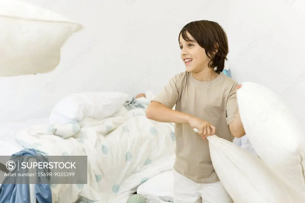 Little boy in pillow fight, smiling