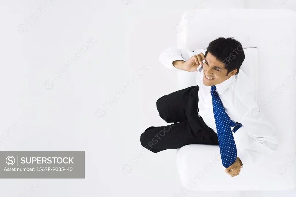 Man using cell phone, tugging at neck tie, overhead view