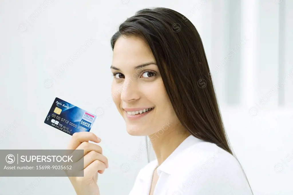 Woman holding credit card, smiling at camera
