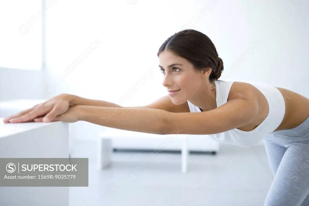 Woman stretching, bending over, arms outstretched