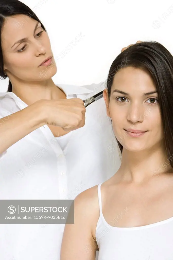 Woman having her hair cut, smiling at camera