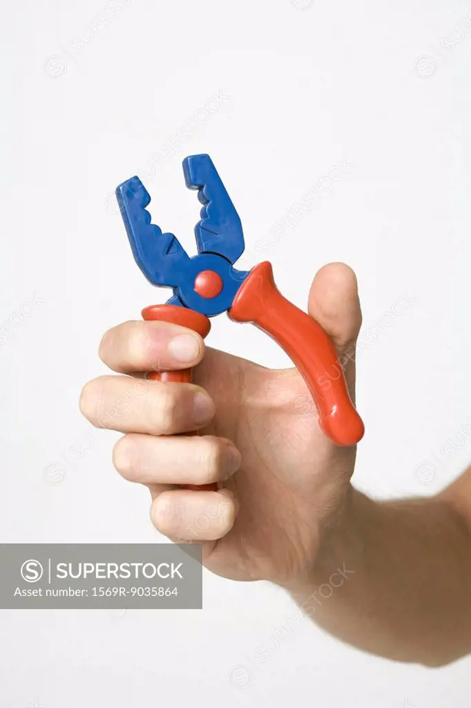 Hand gripping pliers, close-up