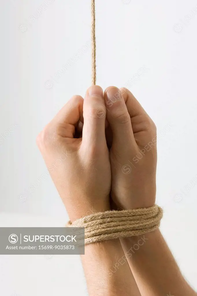Hands bound with rope, close-up