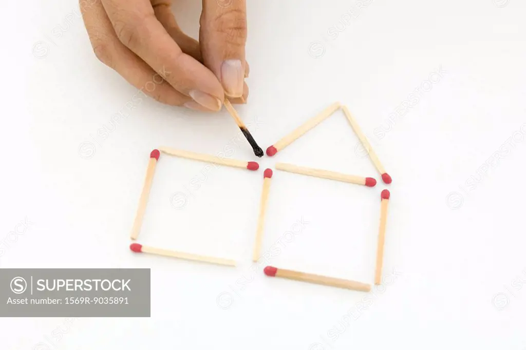 Hand arranging matches, holding one burnt match