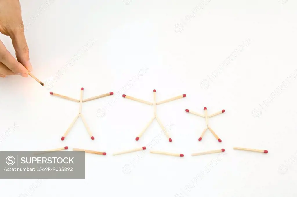Hand holding lit match up to unlit matches arranged as stick figures