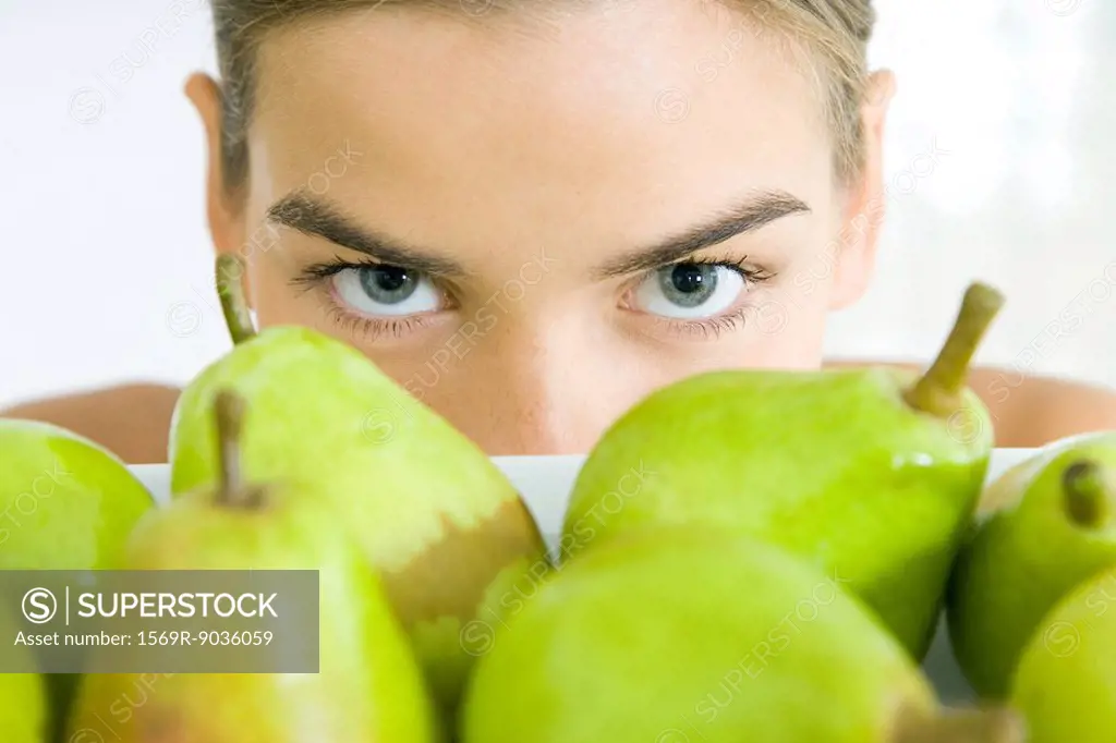 Young woman looking over tray of pears