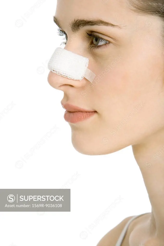 Young woman with bandaged nose, profile, cropped