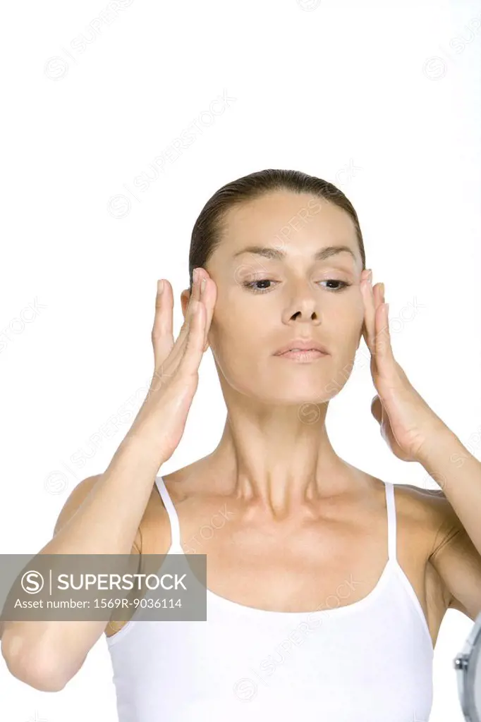 Woman touching face, pulling back cheeks
