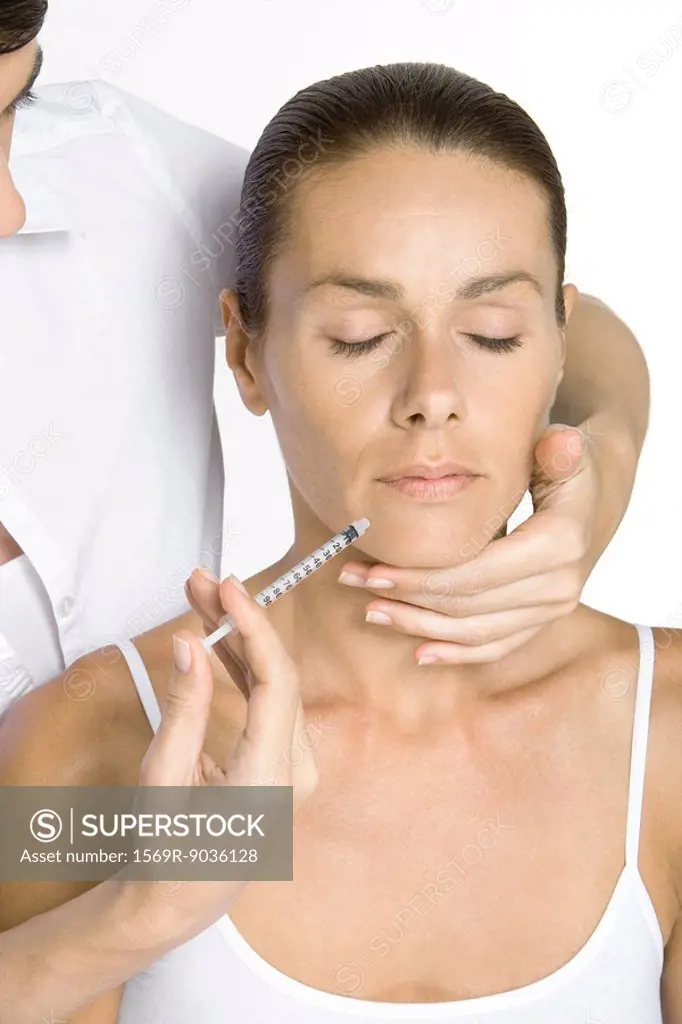 Woman receiving collagen injection, eyes closed