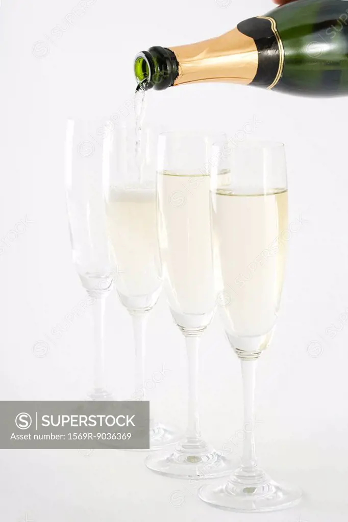 Pouring champagne into glasses, close-up