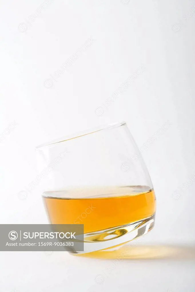 Glass of whiskey tipping, close-up