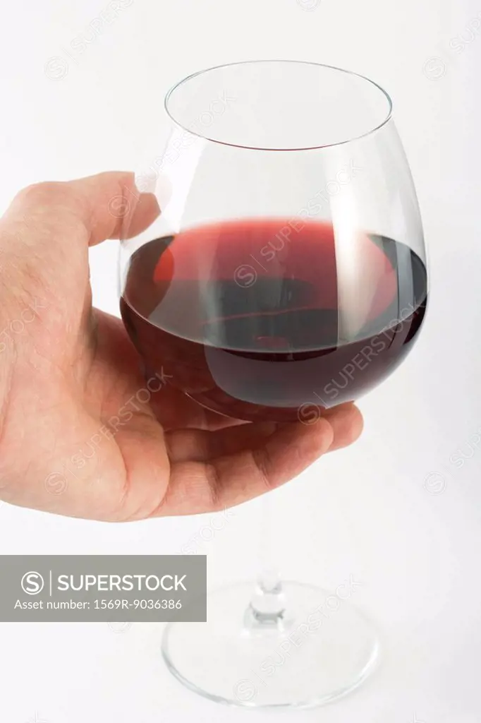 Hand holding glass of red wine