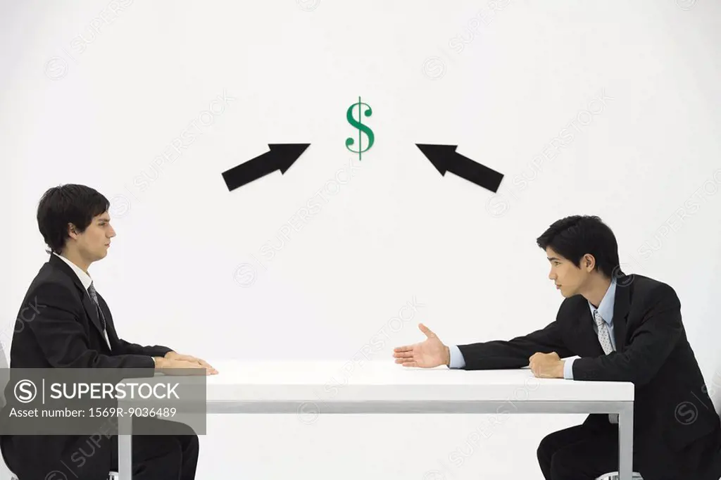 Two businessmen face to face, one reaching to offer his hand, dollar sign and arrows between them