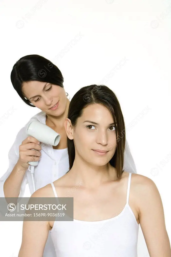 Hair stylist blow drying a woman´s hair
