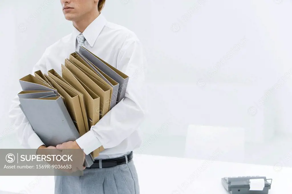Office worker carrying many binders, cropped view