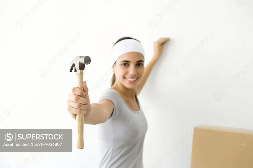 Teen girl showing hammer to the camera, smiling
