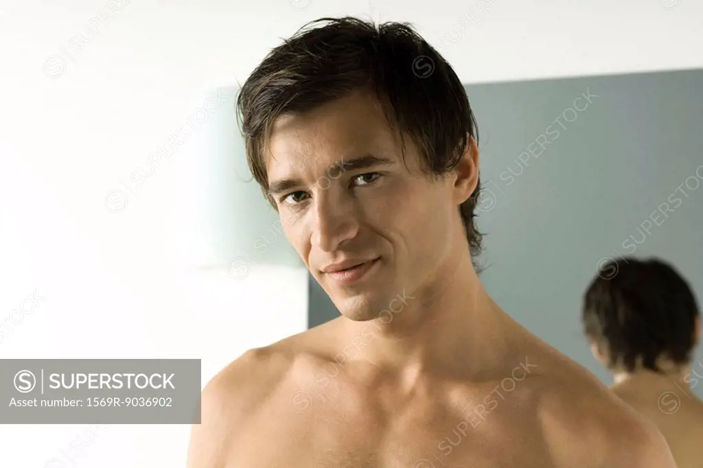 Bare-chested man smiling at camera, portrait