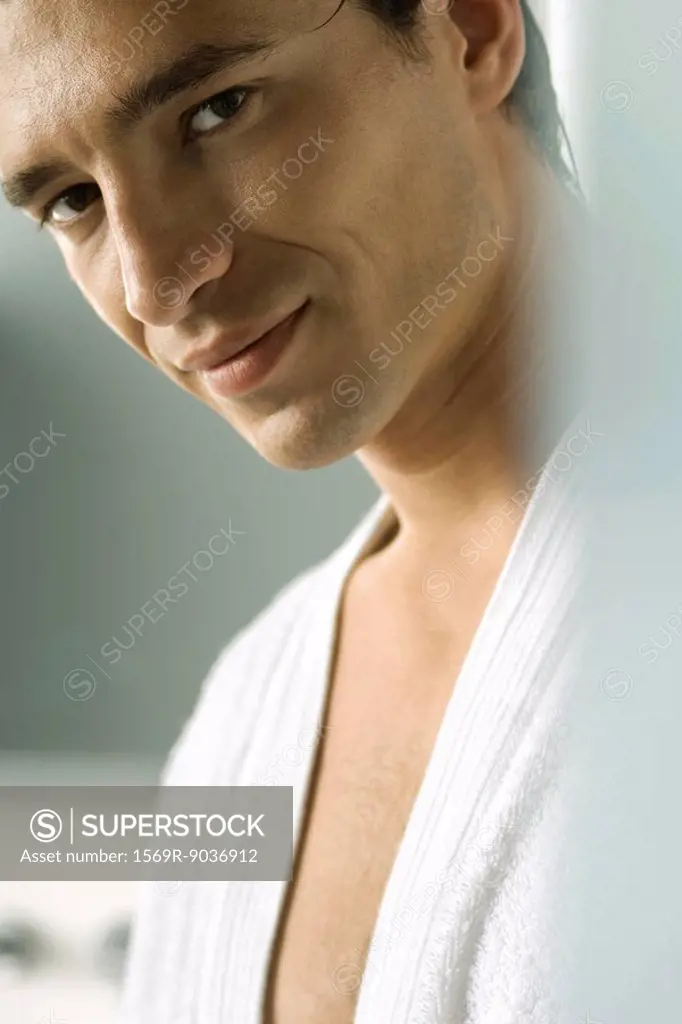 Man in bathrobe smiling seductively at camera, cropped