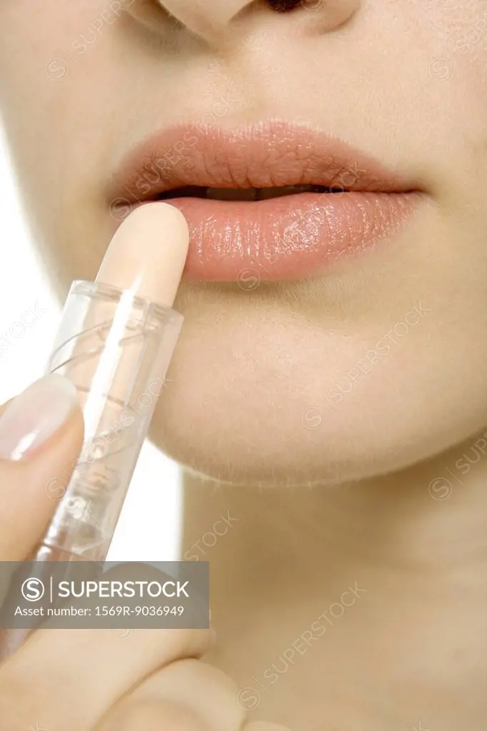 Woman applying lipstick, extreme close-up