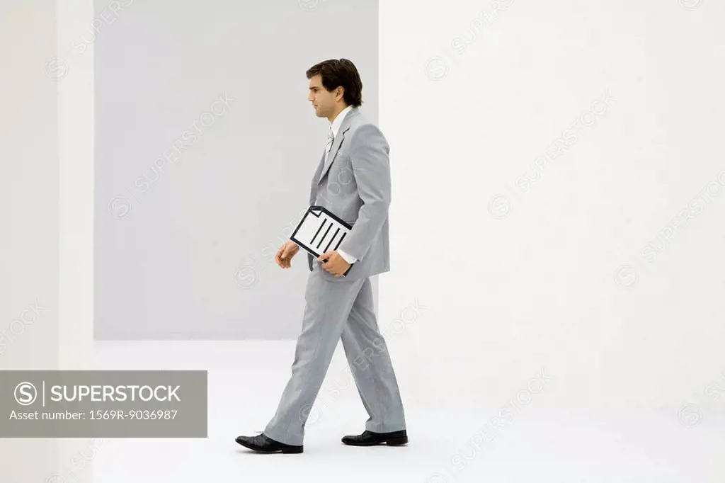 Businessman carrying document, side view