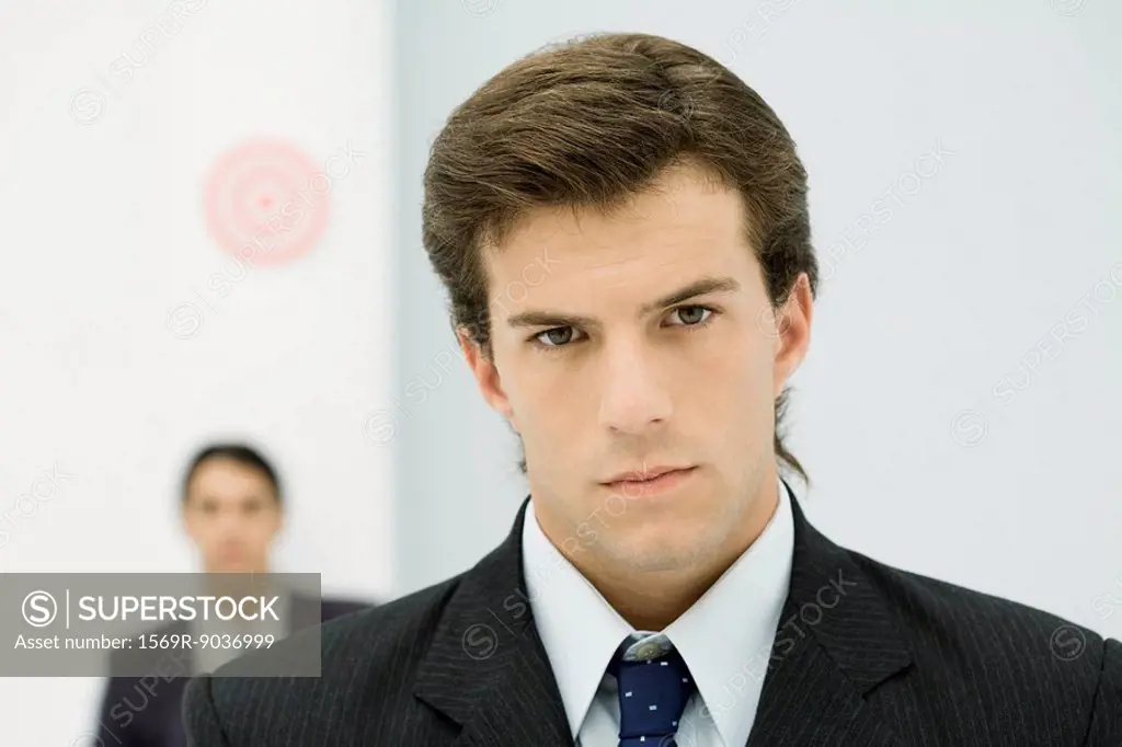Young businessman frowning at camera, close-up