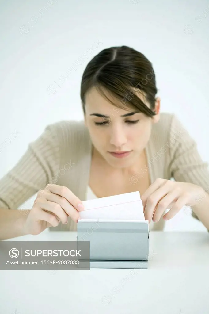 Young woman looking through box of index cards