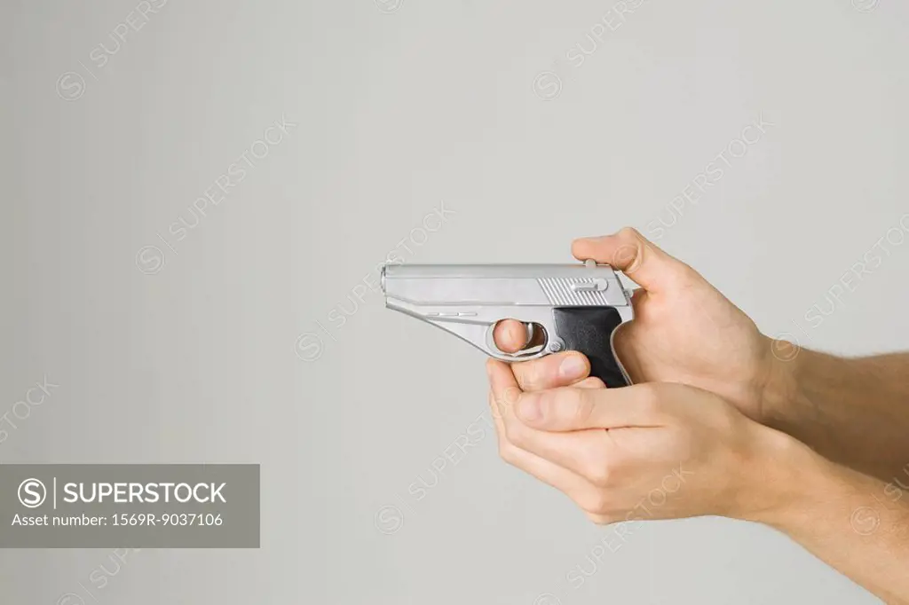 Hands holding and aiming toy gun, side view