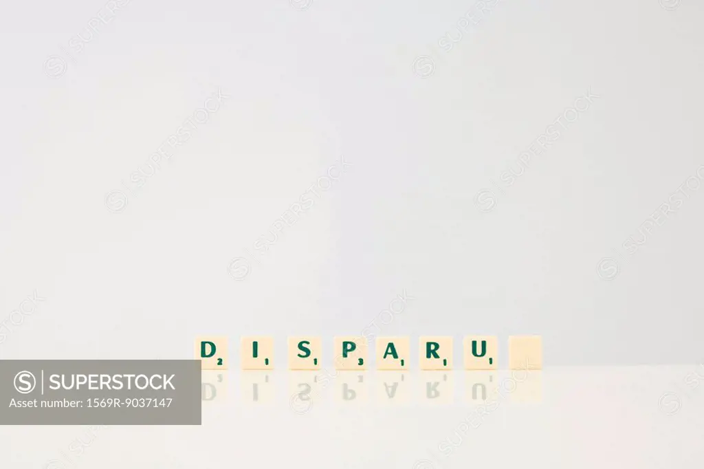 Word game tiles spelling the word Disparu, disappeared in french, with final tile blank